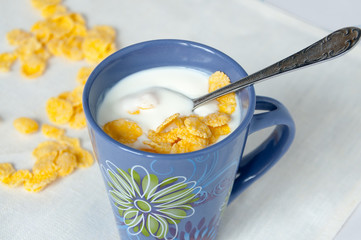 Spoon in a bowl with milk and cornflakes