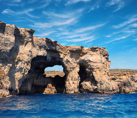 Fototapeta na wymiar Limestone rock caves and blue Mediterranean water of Comino