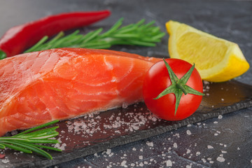 trout with lemon  and tomato on black stone