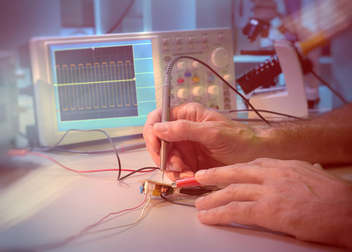 Hands of a senior male engineer testing electronic equipment