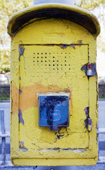 Old weathered yellow New York City police call box.