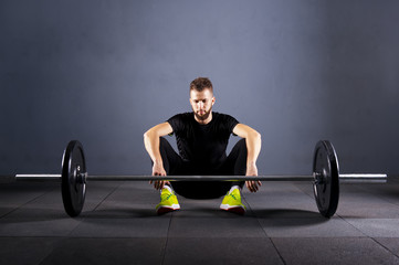 Athlete motivates before barbells exercise at gym