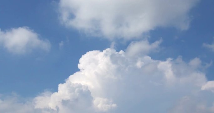 Time lapse shot of white fluffy clouds over blue sky
