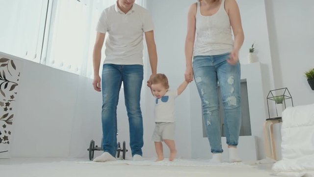 Cute little boy takes the first steps, goes to the white sunny living room