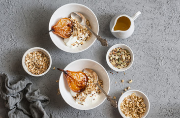 Caramelized baked pears with greek yogurt and granola on a gray background, top view. Healthy breakfast. Flat lay