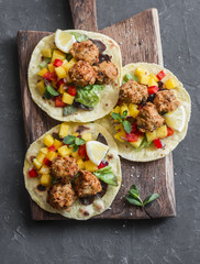 Fish tacos with mango salsa on a wooden cutting board, top view. Delicious appetizer or snack