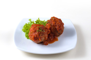 Sweet pork meat balls with tomato sauce and green salad leaf