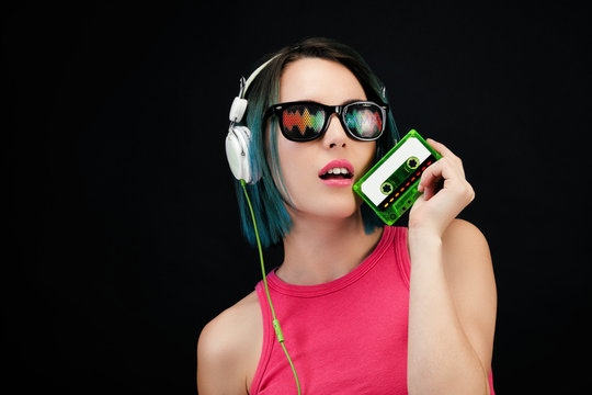 Jeune femme tenant dans sa main une cassette audio