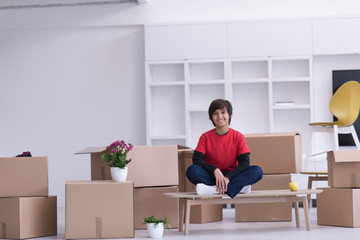 boy sitting on the table with cardboard boxes around him