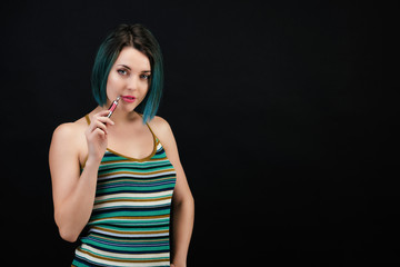 Jeune femme vape une cigarette électronique