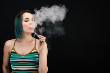Jeune femme vape une cigarette électronique
