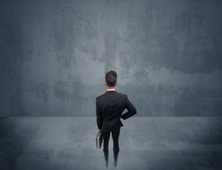 Businessman standing in front of urban wall