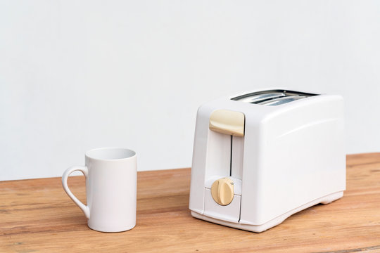 Toaster with white cup on wooden table with copyspace 