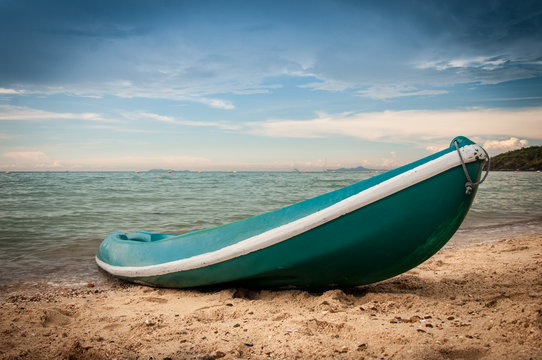 Blue kayak on the beach with vignette effect
