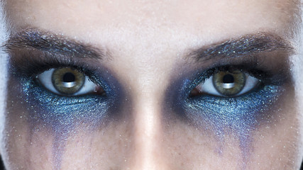closeup eyes of the young woman on a gray background with a vanguard make-up