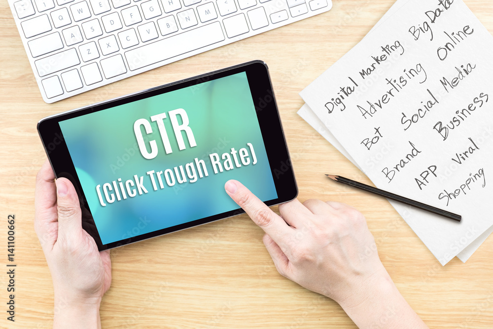 Poster Hand using tablet with CTR ( Click trough rate ) word on screen with list of digital marketing features on paper on work table,Online business concept