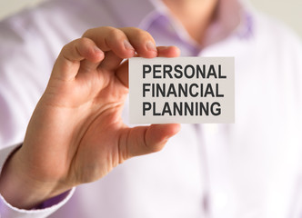 Businessman holding a card with PERSONAL FINANCIAL PLANNING message