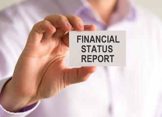 Businessman holding a card with FINANCIAL STATUS REPORT message