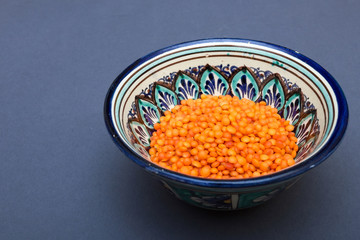 Orange lentils in a colored clay cup