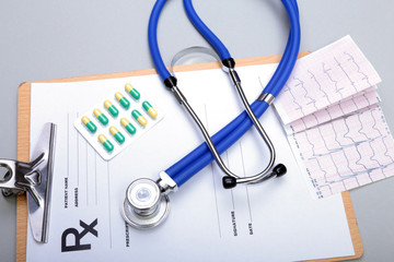 RX prescription, Red heart, asorted pils and a stethoscope on white background