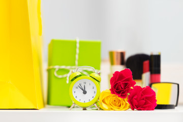 cute shopping bag, make up set, gift, alarm clock and roses on the wonderful mirror background