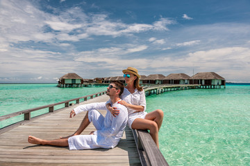 Couple in white on a beach jetty at Maldives