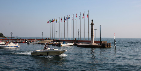 Motor boats against the lighthouse and european flags,Italy
