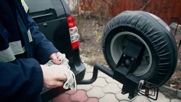 1080i. The young car mechanic wears working gloves for work.