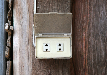 old electrical outlet on wood wall.
