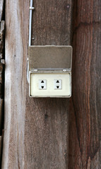 old electrical outlet on wood wall.
