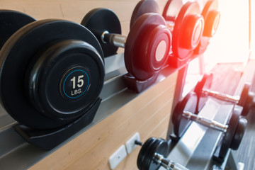 Fototapeta na wymiar Rows of dumbbells in the gym with hign contrast