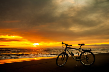 Fototapeta premium Tourist bike on the coast of the sea at sunset time