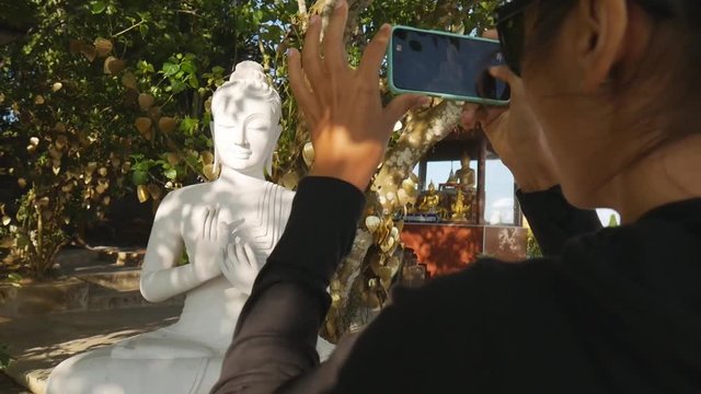 Young Caucasian Tourist Girl Taking Photo of White Buddha Statue at Phuket, Thailand. HD Slowmotion.