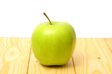 Green apple on wood table isolated on white background