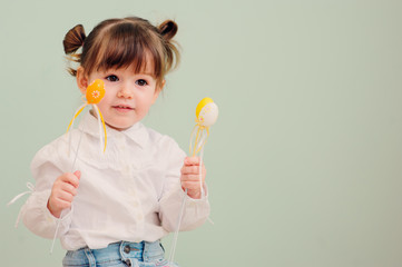 close up indoor portrait of cute happy baby girl playing with easter decorations