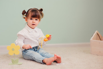 close up indoor portrait of cute happy baby girl playing with easter decorations