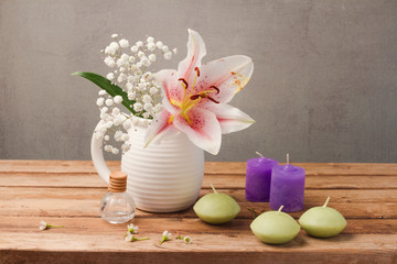 Spa and wellness concept with flowers and candles on wooden table over rustic background