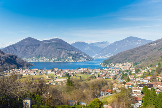 Lake Lugano, Porto Ceresio, Italy. Picturesque aerial view of Porto Ceresio and Besano. In the background Switzerland with Marcote, Melide and the Alps