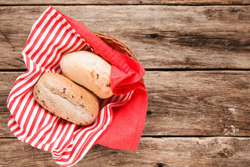 Two fresh bread buns in the basket on wooden table, top view. Food background. Free space for text, menu photo.
