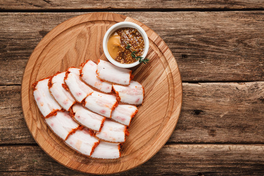 Fototapeta Ukrainian salo served with mustard, top view. Background of rustic wooden table with free space for text.