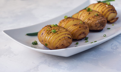 Baked hasselback potatoes with onion and spice