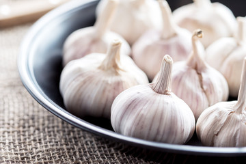 Garlic cloves and garlic bulb on black plate.Spicy cooking ingredient. Natural herbal medicine vegetable.