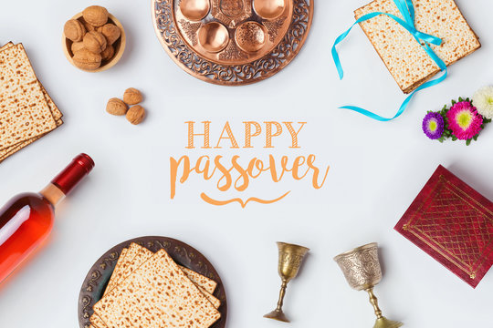 Jewish holiday Passover Pesah greeting card with wine, matza and seder plate. View from above. Flat lay