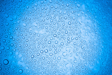 Rain droplets on blue glass background, Water drops on glass.