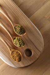 Various spices spoons on wooden table. Top view with copy space
