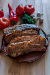 Grilled pork chop with bay leaf, pepper, garlic and dill on wooden board - selective focus, Vertical orientation
