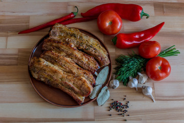 Grilled pork chop with bay leaf, pepper, garlic and dill on wooden board - selective focus