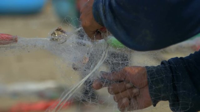 Male hands are twisted the fishing net close-up