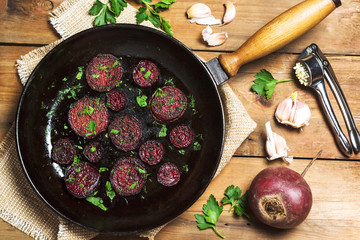 Fried beet slices on a cast-iron frying pan.