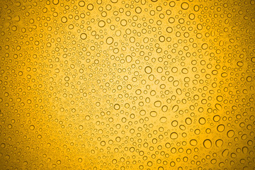 Water drops on yellow glass, Rain droplets on glass background.